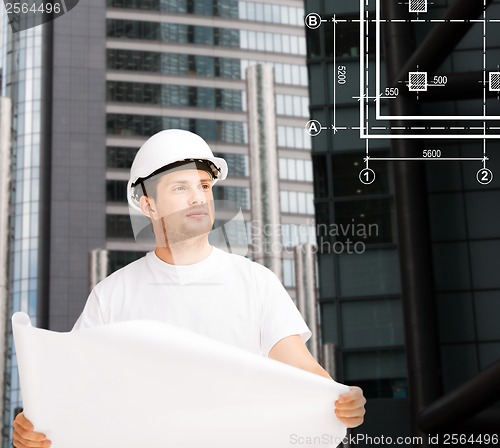 Image of male architect in helmet looking at blueprint