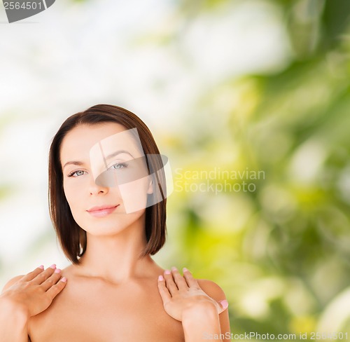 Image of beautiful woman touching her shoulders