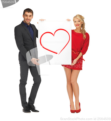 Image of smiling couple holding big white board with heart