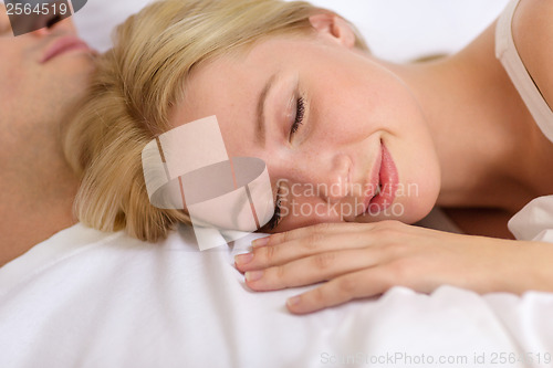 Image of happy couple sleeping in bed