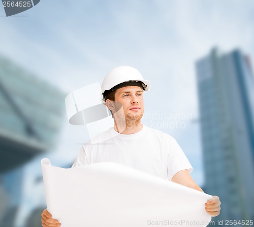 Image of male architect in helmet looking at blueprint