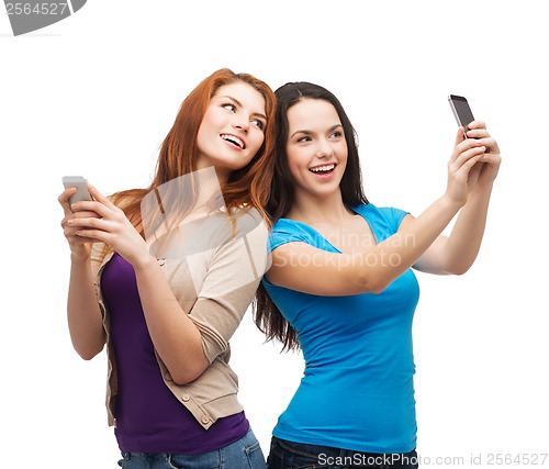 Image of two smiling teenagers with smartphones