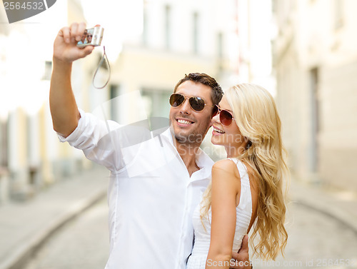Image of travelling couple taking photo picture with camera