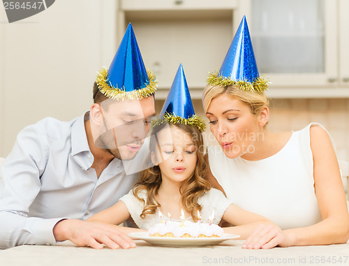 Image of smiling family in blue hats with cake