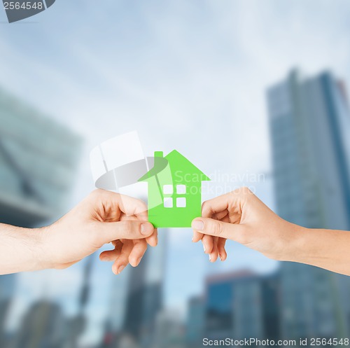 Image of couple hands holding green house