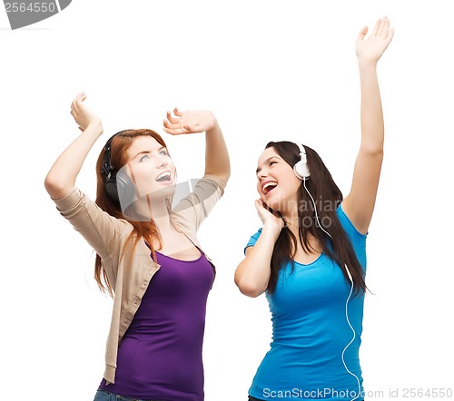 Image of two laughing girls with headphones dancing