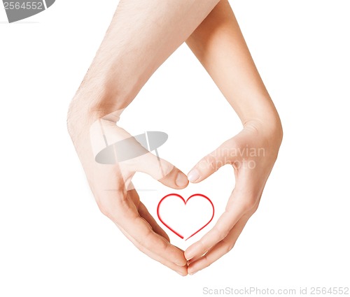 Image of woman and man hands showing heart shape