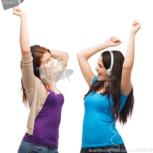 Image of two laughing girls with headphones dancing