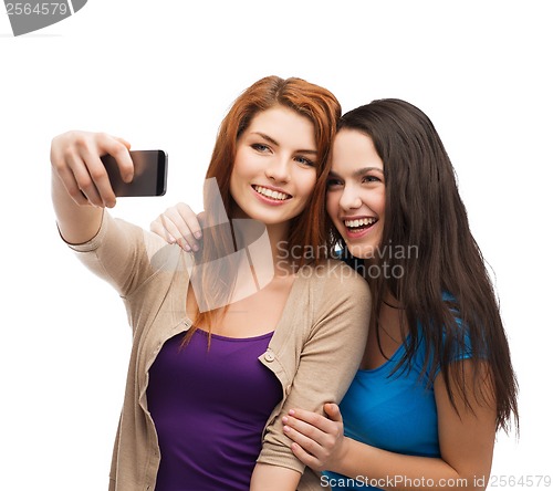 Image of two smiling teenagers with smartphone