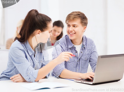 Image of two smiling students with laptop computer