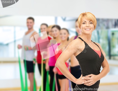 Image of group of smiling people exercising in the gym