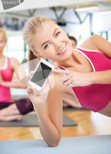 Image of woman lying on the floor with smartphone