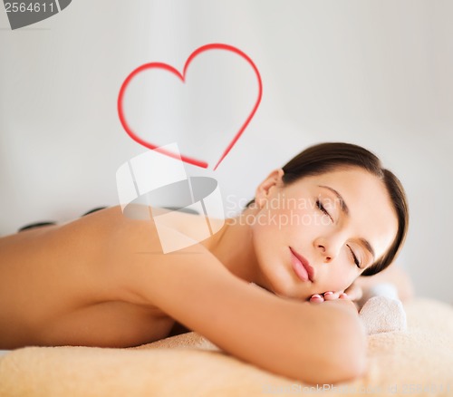 Image of beautiful woman in spa salon with hot stones