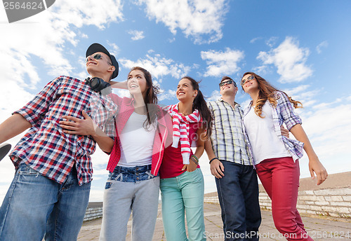 Image of smiling teenagers in sunglasses hanging outside