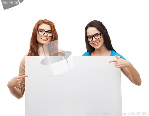 Image of two smiling girls with eyeglasses and blank board