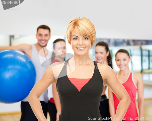 Image of group of smiling people exercising in the gym