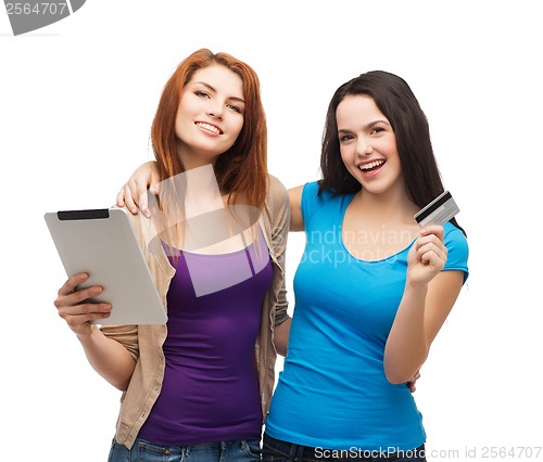 Image of two smiling girls with tablet pc and credit card