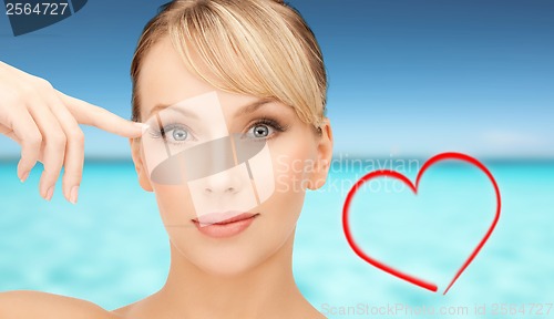 Image of beautiful woman touching her eye area