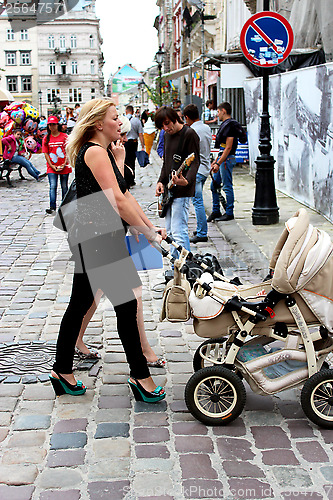 Image of mother with perambulator walking along the street