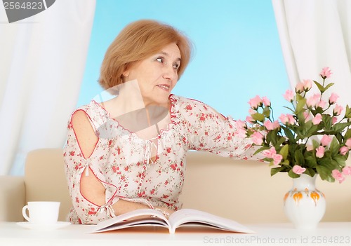 Image of Beautiful older woman resting in the bedroom