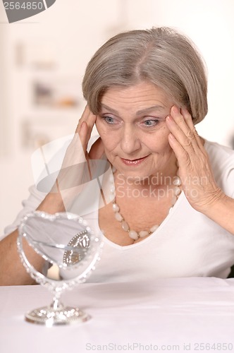 Image of Senior woman doing makeup