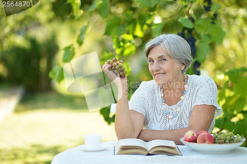 Image of Woman with grapes and book