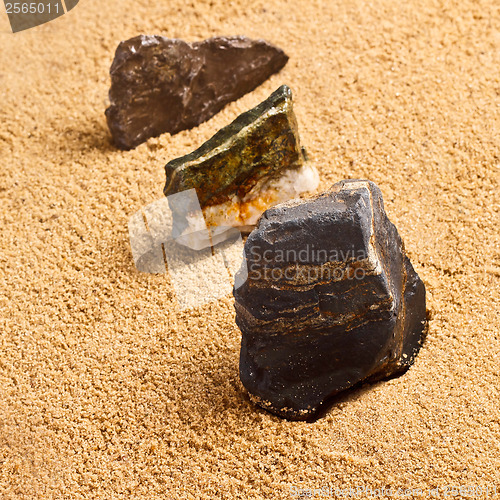 Image of three stones in the sand texture