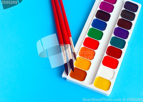 Image of brushes watercolors paints children on blue background