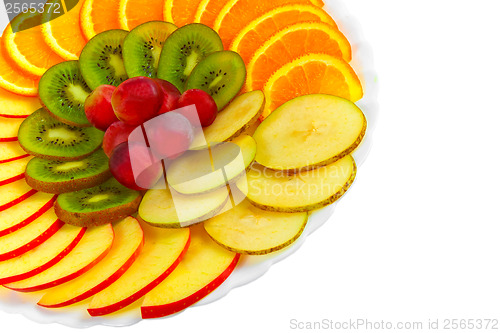 Image of Salad apples oranges grapes kiwi fruit slices on a plate isolate