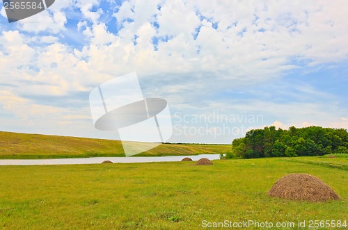 Image of field landscape with river and hay