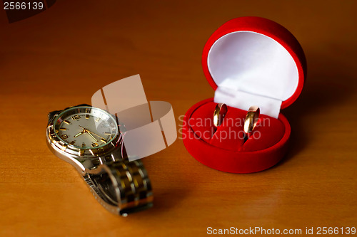 Image of wedding ring in a box and watches on the table