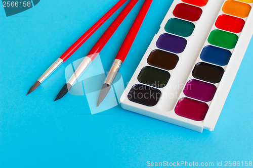 Image of brushes for watercolors paints children on blue background