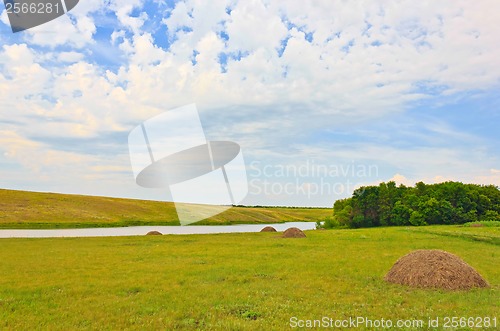 Image of field landscape with river and hay
