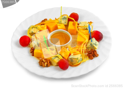 Image of Different types of cheese appetizer with honey, nuts and grapes