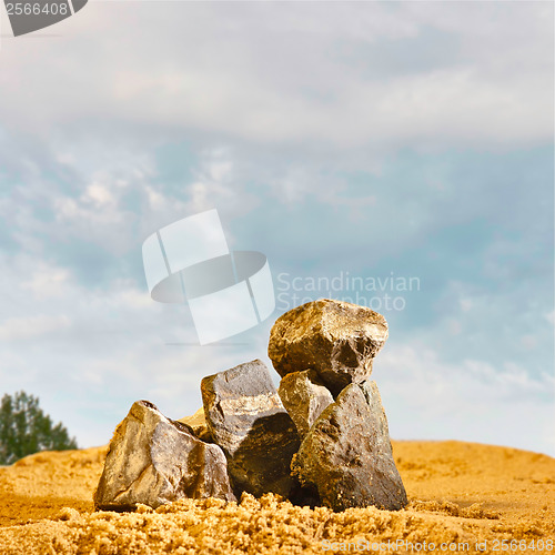 Image of stones in the sand against the blue sky