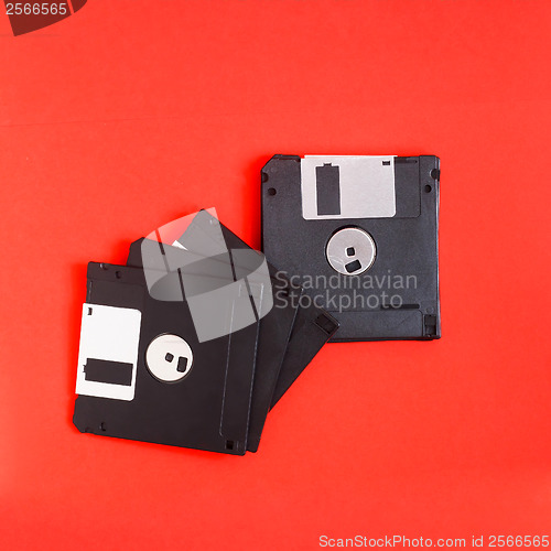 Image of floppy disk magnetic computer data storage support on a red back