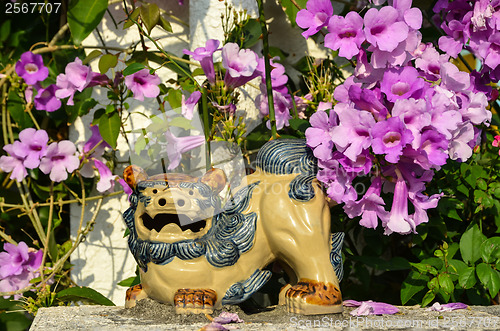 Image of Shisa figure and pink flowers