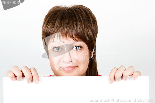 Image of Young girl looking from behind a white sheet