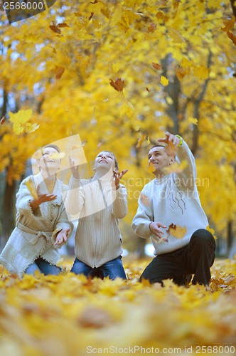 Image of Beautiful family throw autumn leaves
