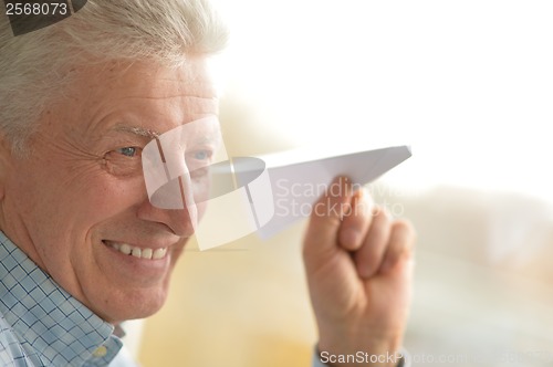 Image of Senior man with paper plane