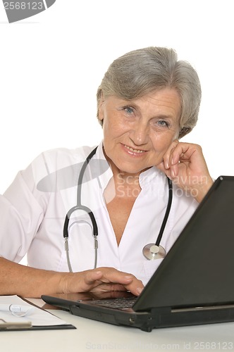 Image of Elderly woman doctor sitting with laptop