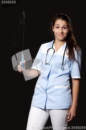 Image of Young female doctor with stethoscope and syringe