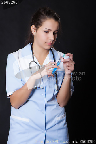 Image of Young female doctor with stethoscope and syringe
