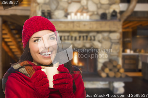 Image of Mixed Race Girl Enjoying Warm Fireplace and Holding Mug