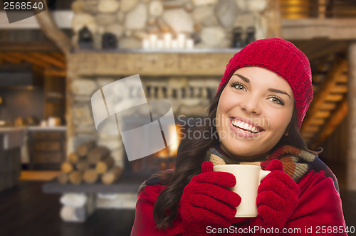 Image of Mixed Race Girl Enjoying Warm Fireplace and Holding Mug