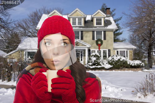 Image of Woman in Winter Clothing Holding Mug Outside in Snow