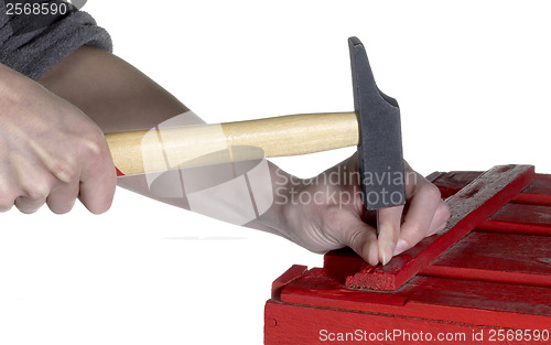 Image of hammering a red wooden box