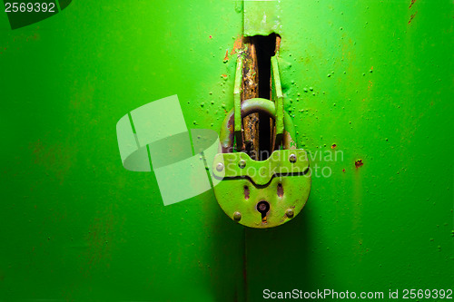 Image of old padlock on the iron green texture