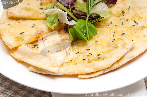 Image of garlic pita bread pizza with salad on top