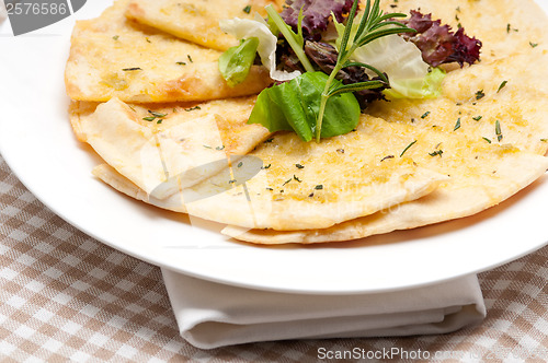 Image of garlic pita bread pizza with salad on top